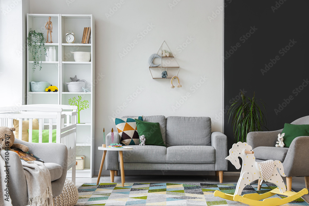 Stylish interior of childrens room with baby bed and shelving unit