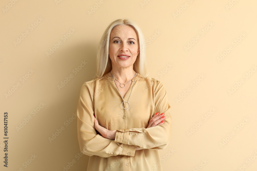 Mature blonde woman on beige background