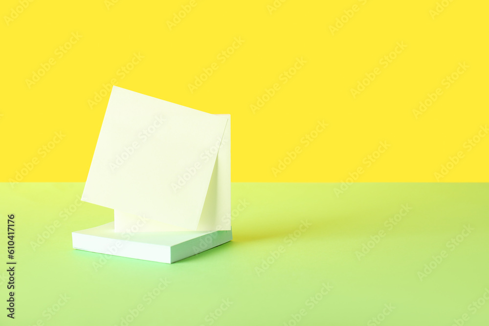 Sticky notes on green table near yellow wall