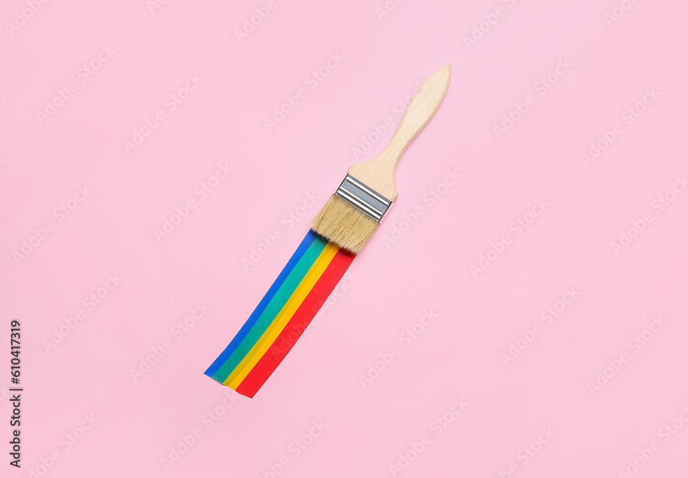 Paint brush with adhesive tapes on pink background