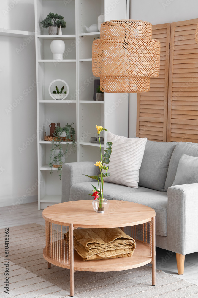 Beautiful ikebana on coffee table in interior of living room