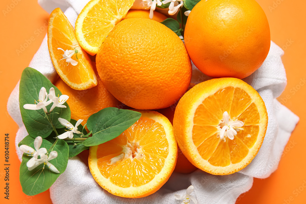 Bowl of oranges with blooming branch on color background