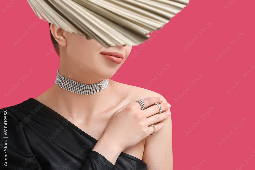 Beautiful young woman wearing elegant jewelry near red wall