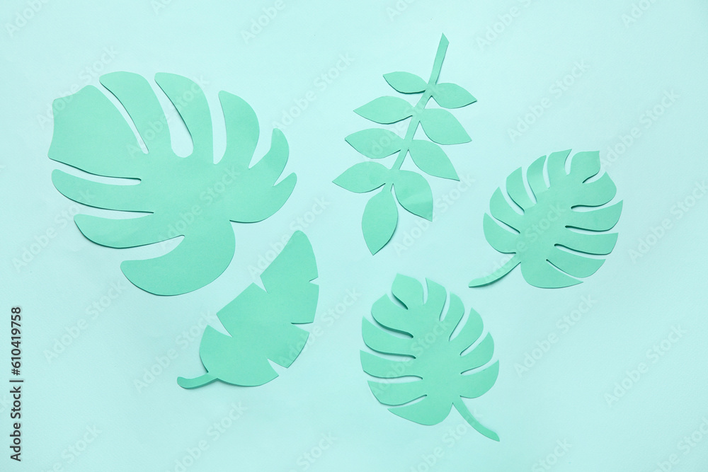 Different tropical leaves on pale turquoise background