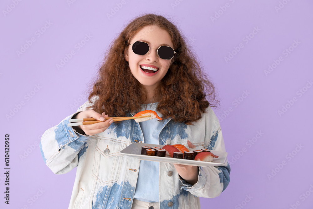 Young woman with sushi on lilac background