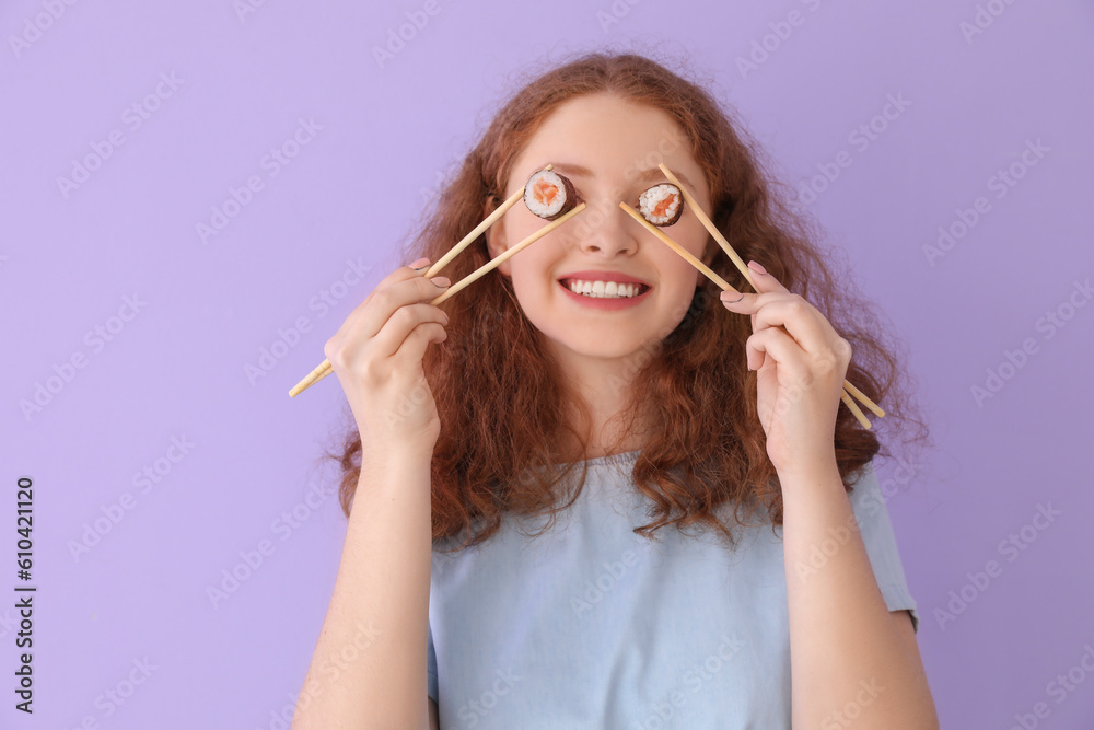 Young woman with sushi rolls on lilac background