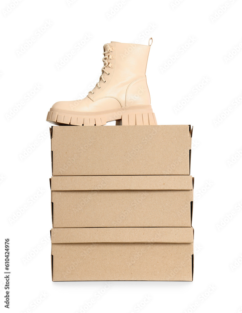 Cardboard boxes and stylish beige boot on white background