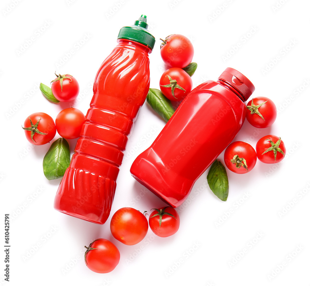 Bottles of ketchup and tomatoes on white background