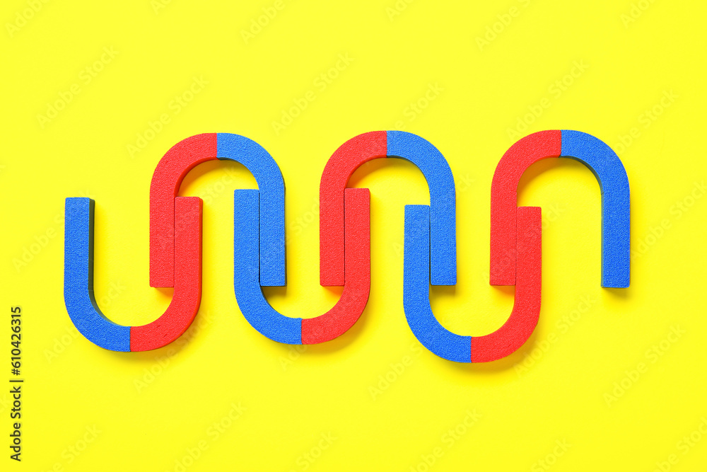 Horseshoe shaped magnets on yellow background