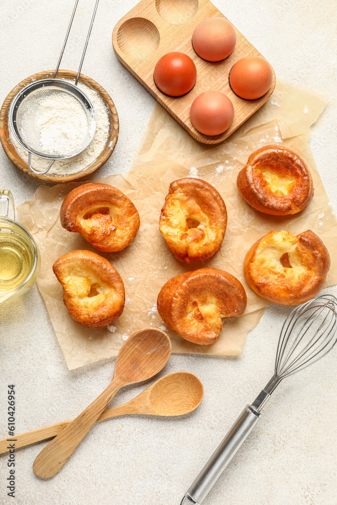 Tasty Yorkshire pudding and ingredients on light background