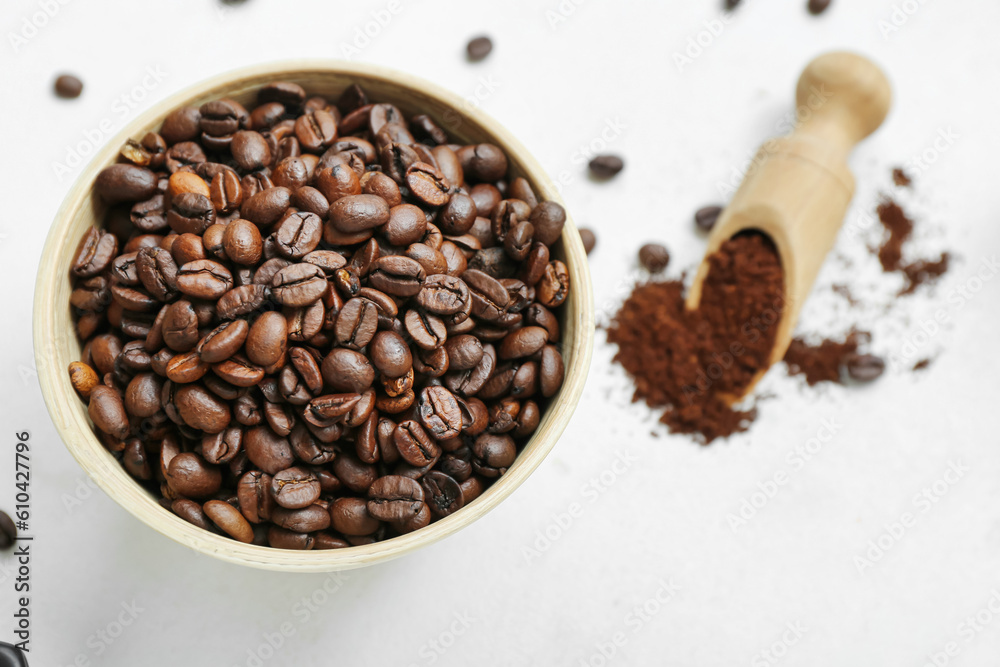 Bowl with coffee beans on light background