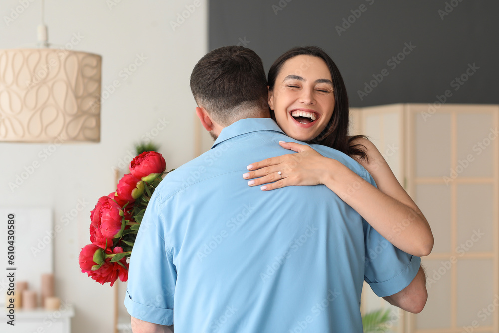 Happy engaged couple hugging at home