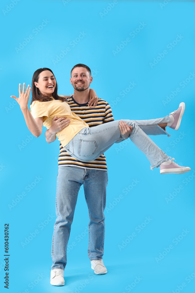 Happy engaged couple on blue background