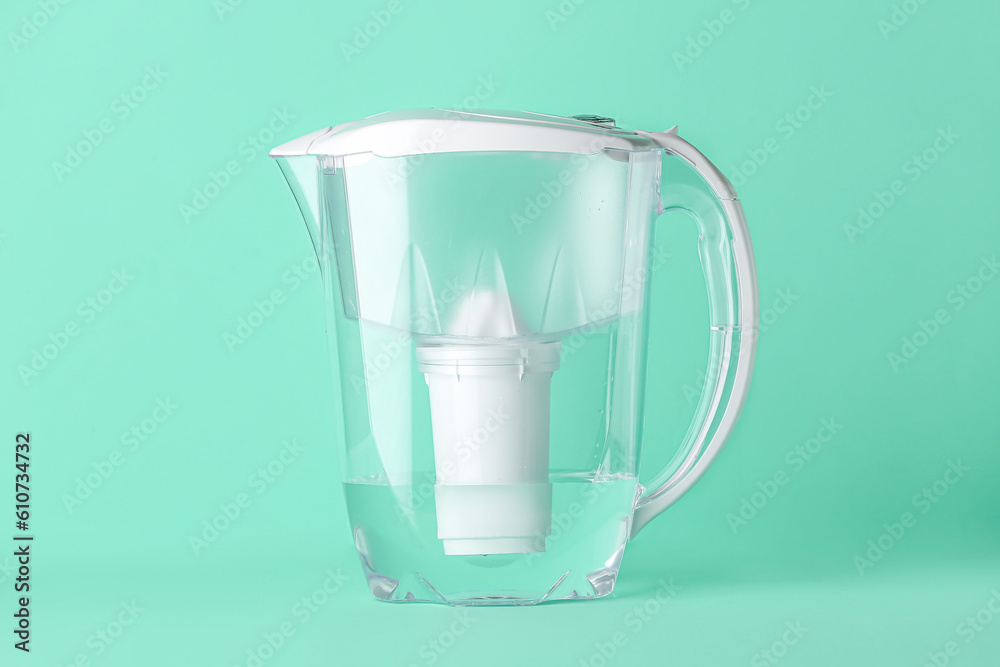 Water filter jug on green background