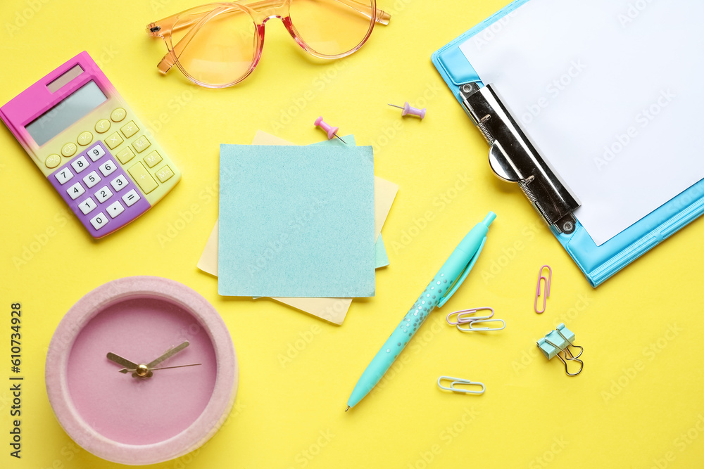 Sticky notes with stationery and alarm clock on yellow background. Update concept