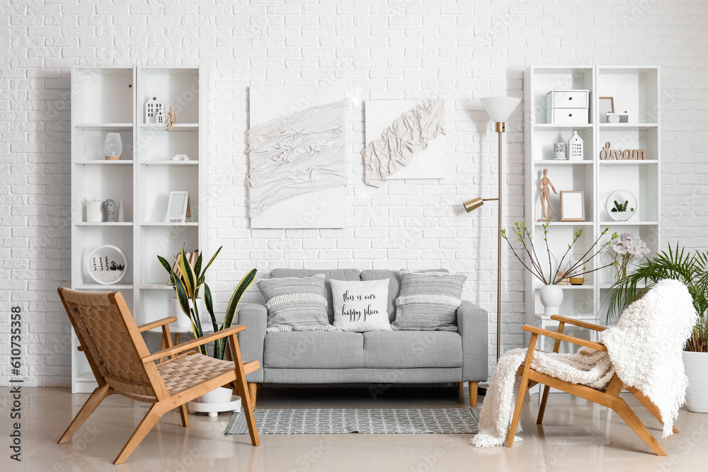 Stylish interior of light living room with comfortable sofa and posters