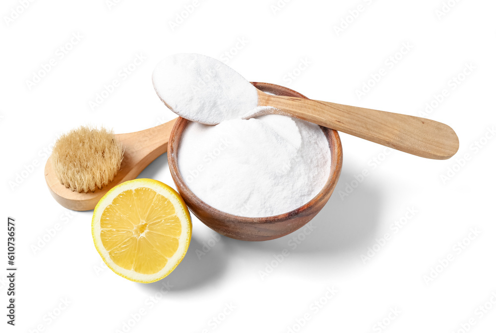 Bowl of baking soda, cleaning brush and lemon on white background