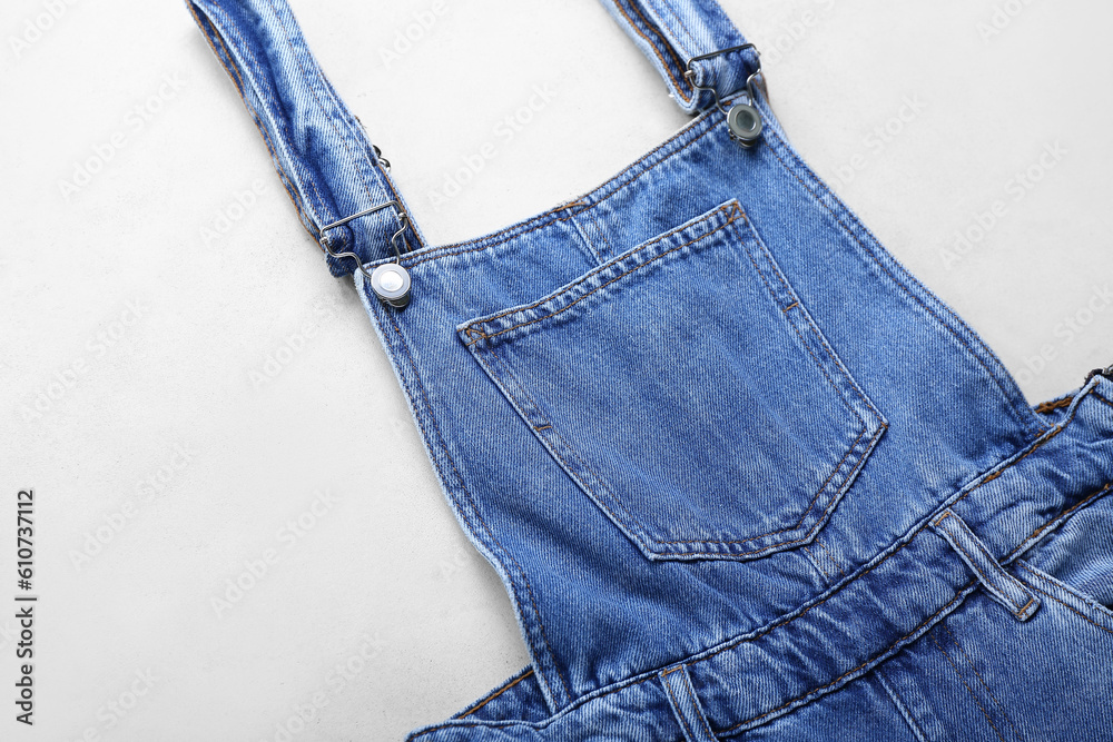 Denim jumpsuit on white background, closeup