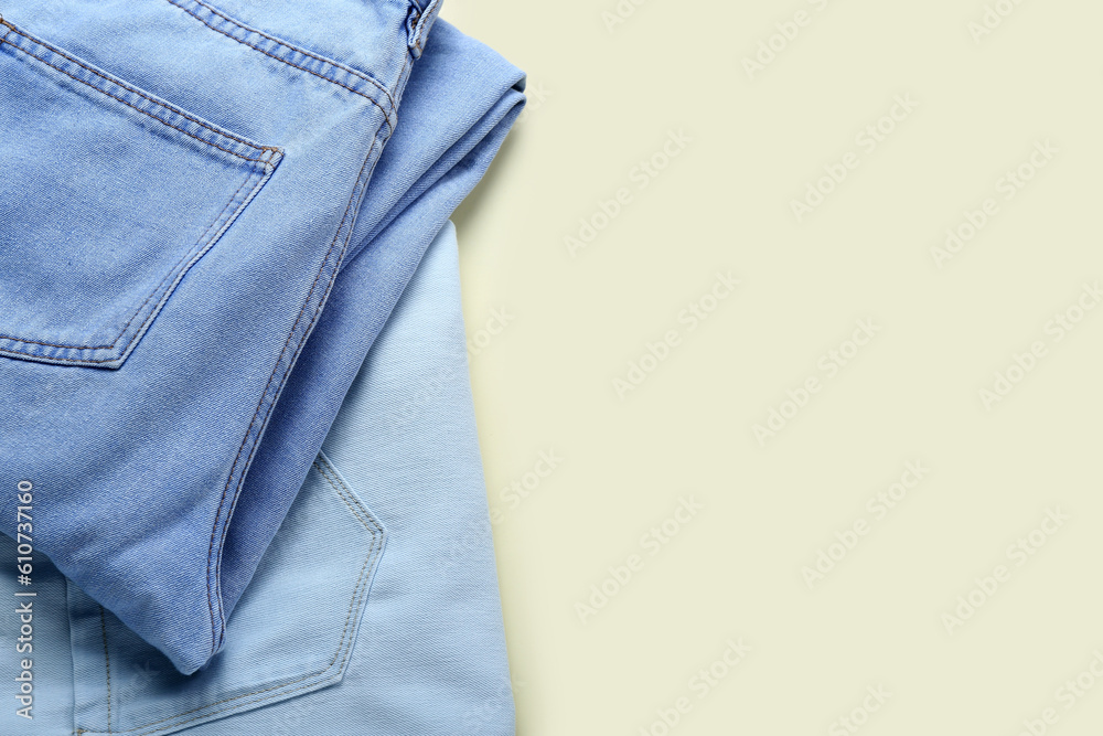 Stylish jeans on beige background, closeup