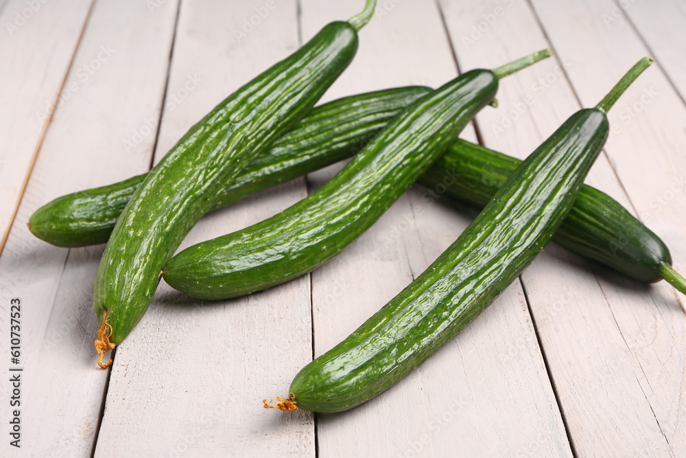 Fresh cucumber on light wooden background