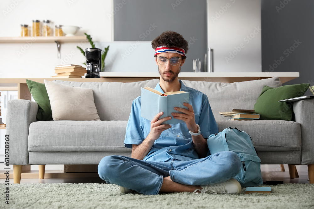 Male student reading book at home