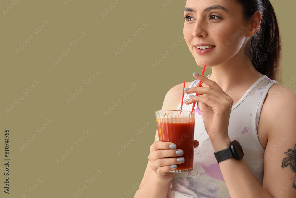 Sporty young woman with glass of vegetable juice on green background, closeup