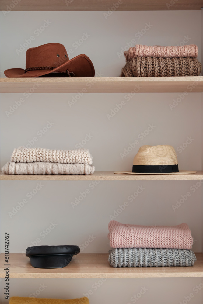 Shelves with stylish clothes and accessories in boutique, closeup