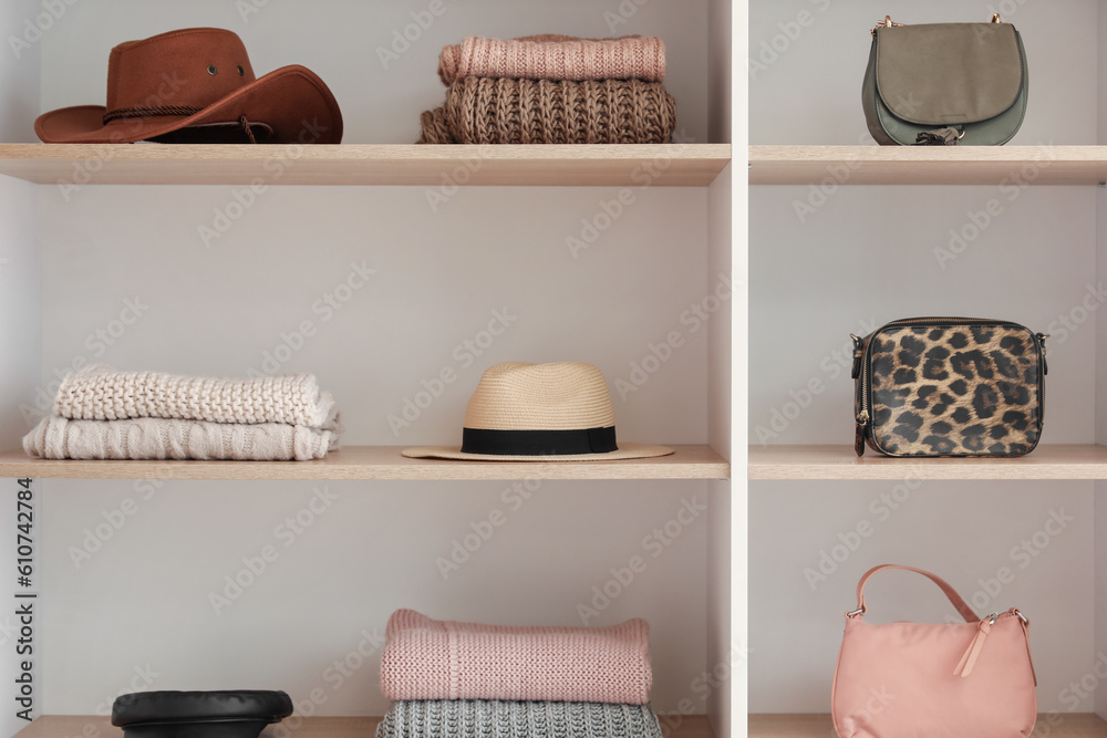 Shelves with stylish clothes and accessories in boutique, closeup