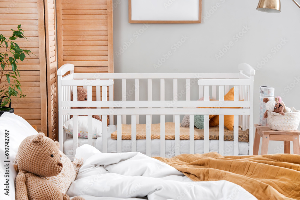 Baby crib in interior of light bedroom