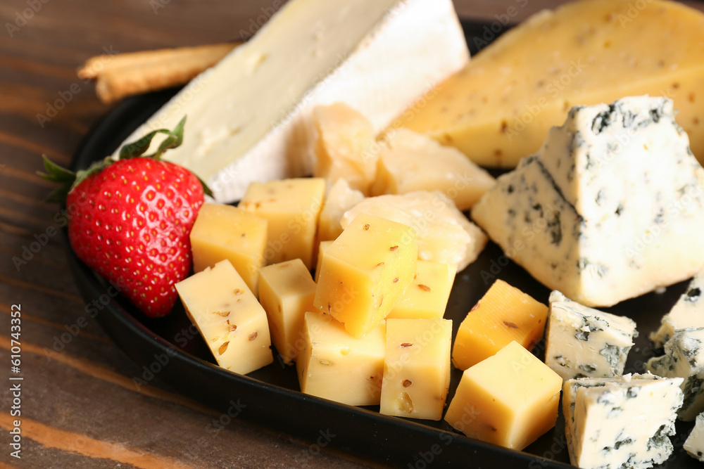 Tray with pieces of tasty cheese on table, closeup