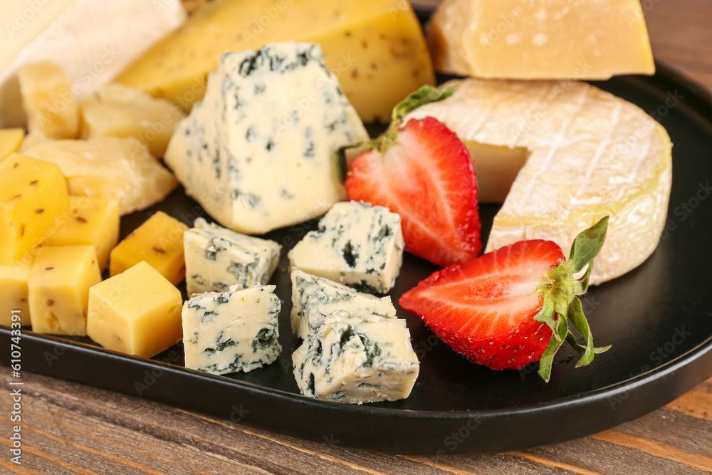 Tray with pieces of tasty cheese on table, closeup