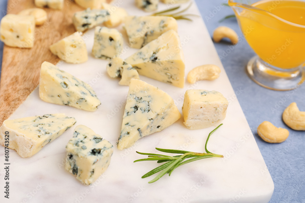 Board with pieces of tasty cheese on table, closeup