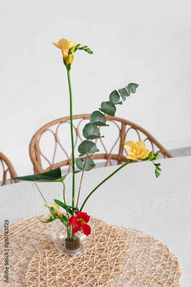 Beautiful ikebana on dining table in room