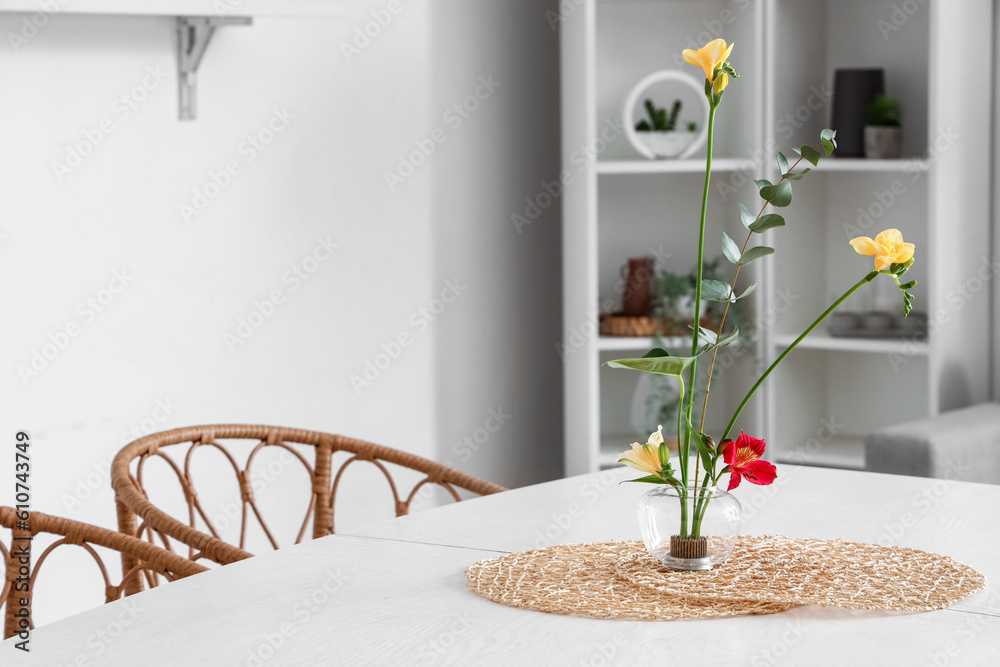 Beautiful ikebana on dining table in room