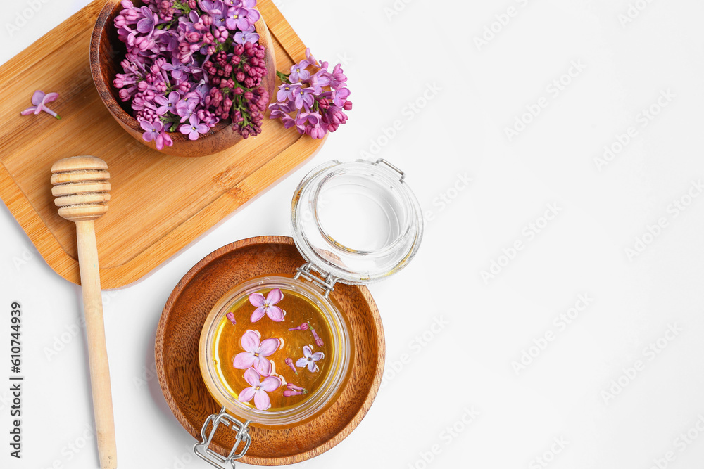 Jar of honey and lilac flowers with wooden board on white background