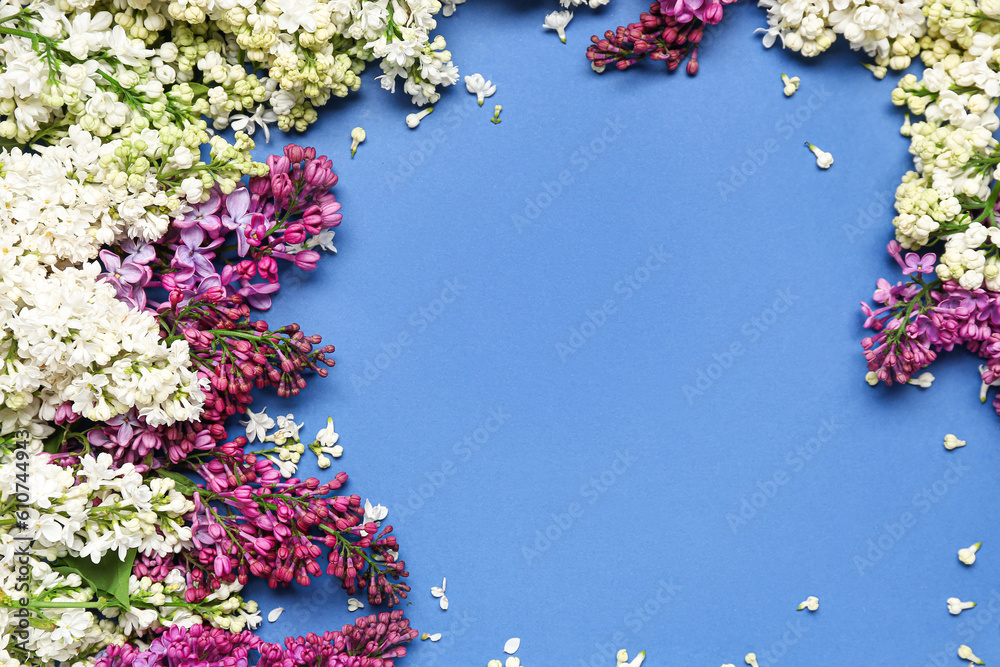 Frame made of lilac twigs and flowers on blue background