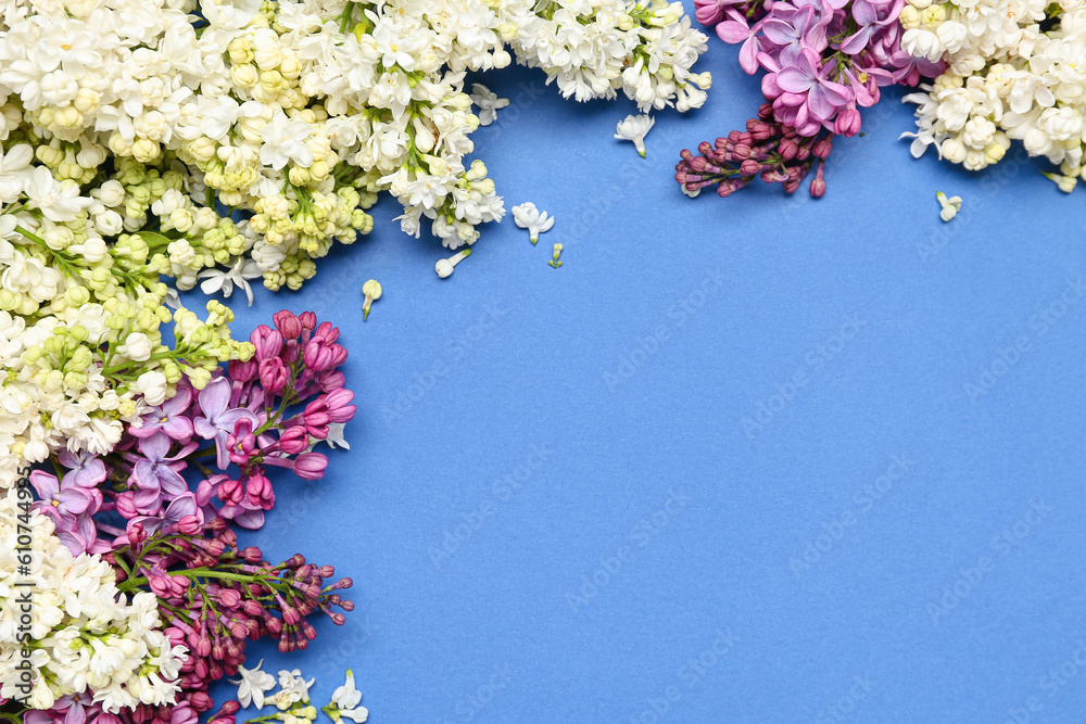 Frame made of lilac twigs and flowers on blue background