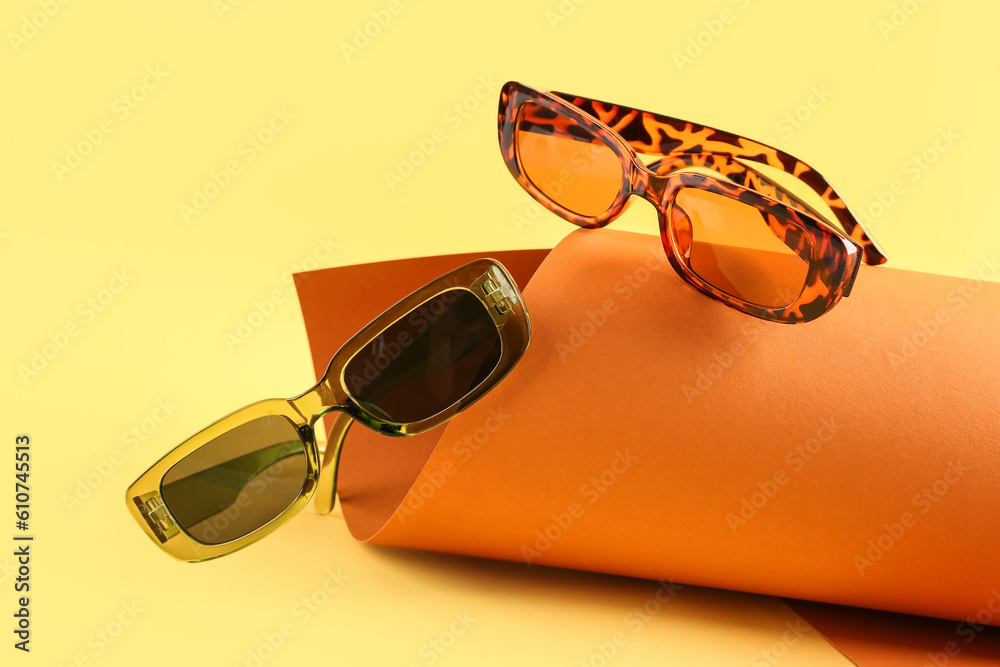 Stylish sunglasses on color background