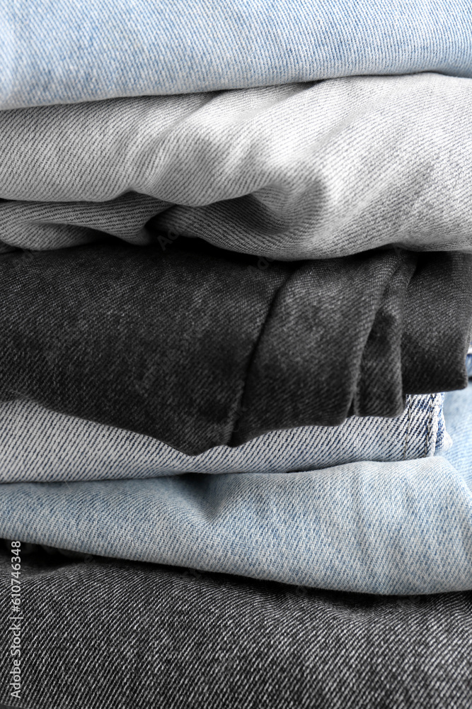 Different folded denim jeans as background, closeup