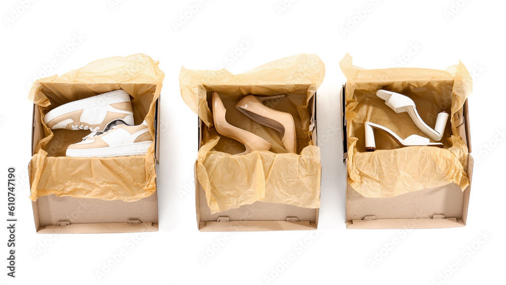 Cardboard boxes with different shoes on white background