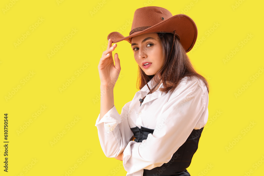 Beautiful cowgirl on yellow background