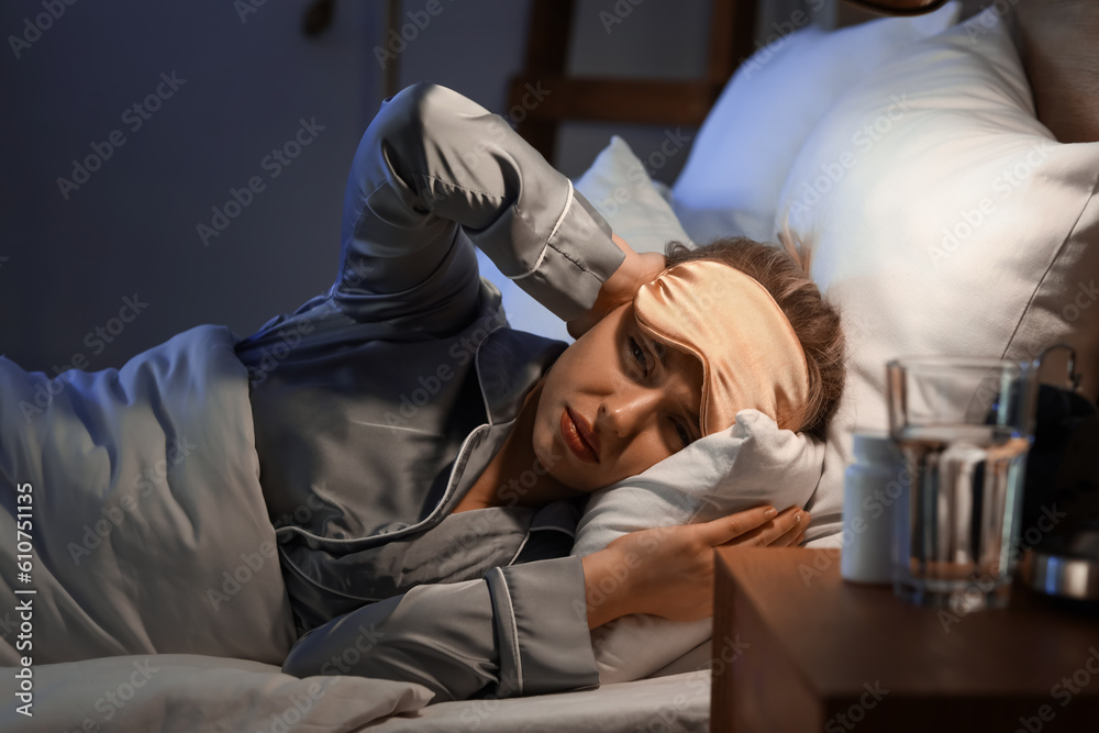 Young woman trying to sleep in bed at night