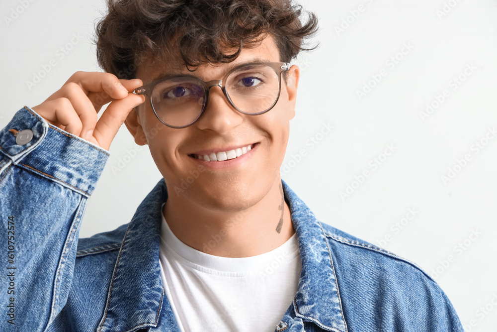 Young man in stylish eyeglasses on light background, closeup