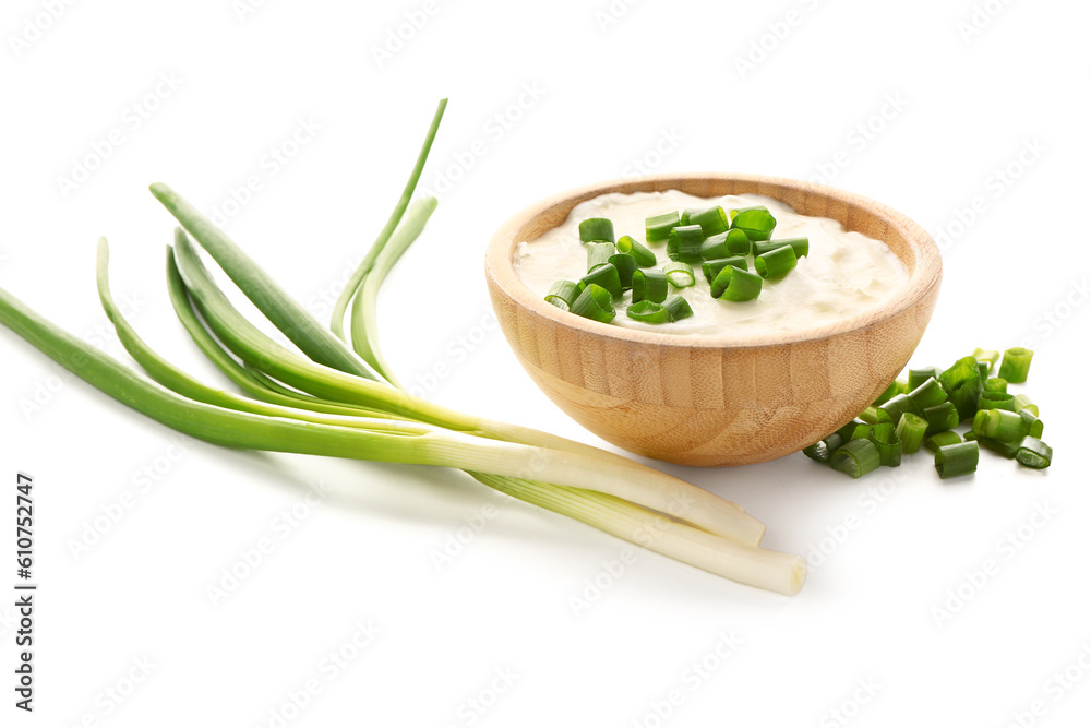 Bowl of tasty sour cream with sliced green onion on white background