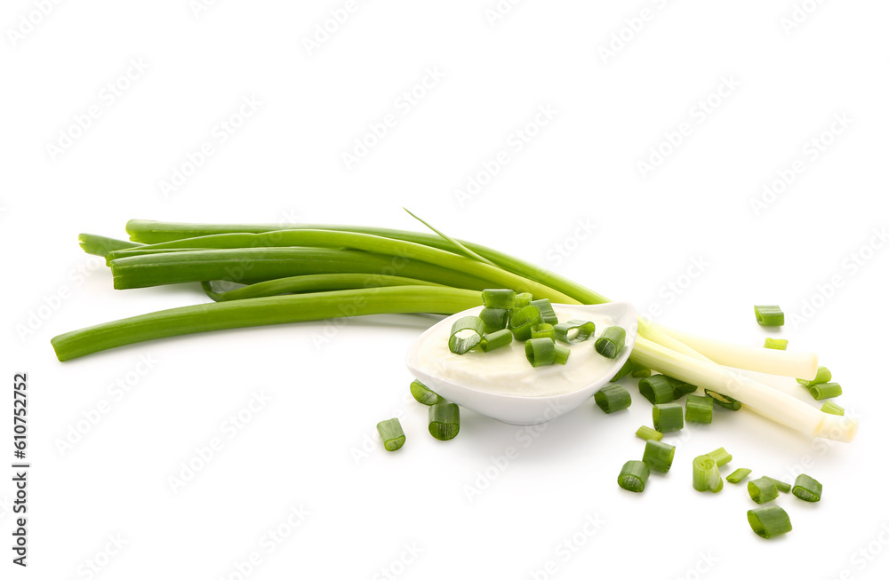 Gravy boat of tasty sour cream with sliced green onion on white background