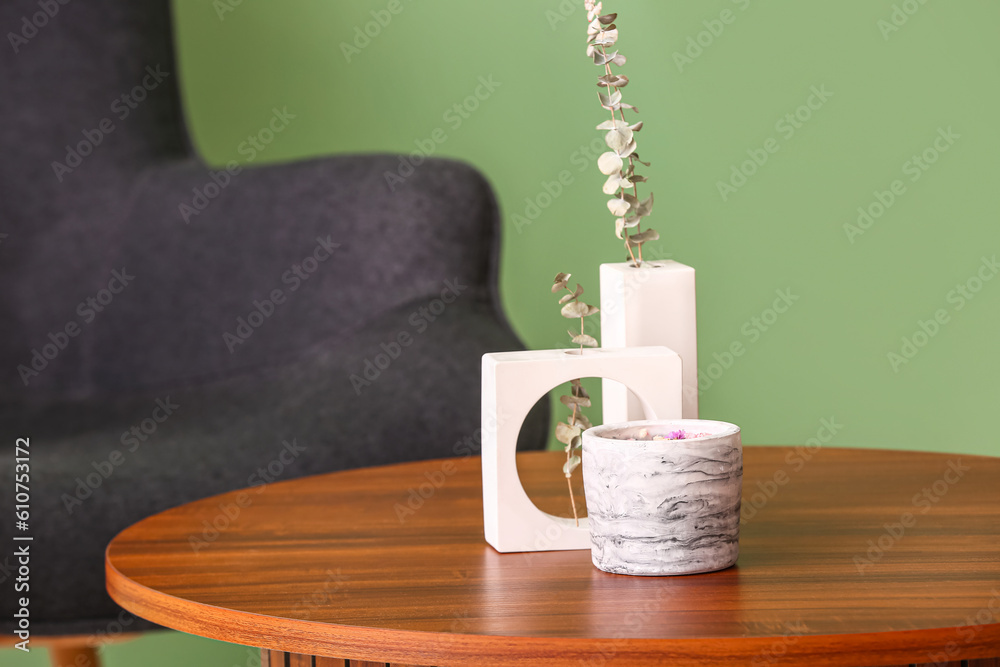 Holder with candle and decor on table in room