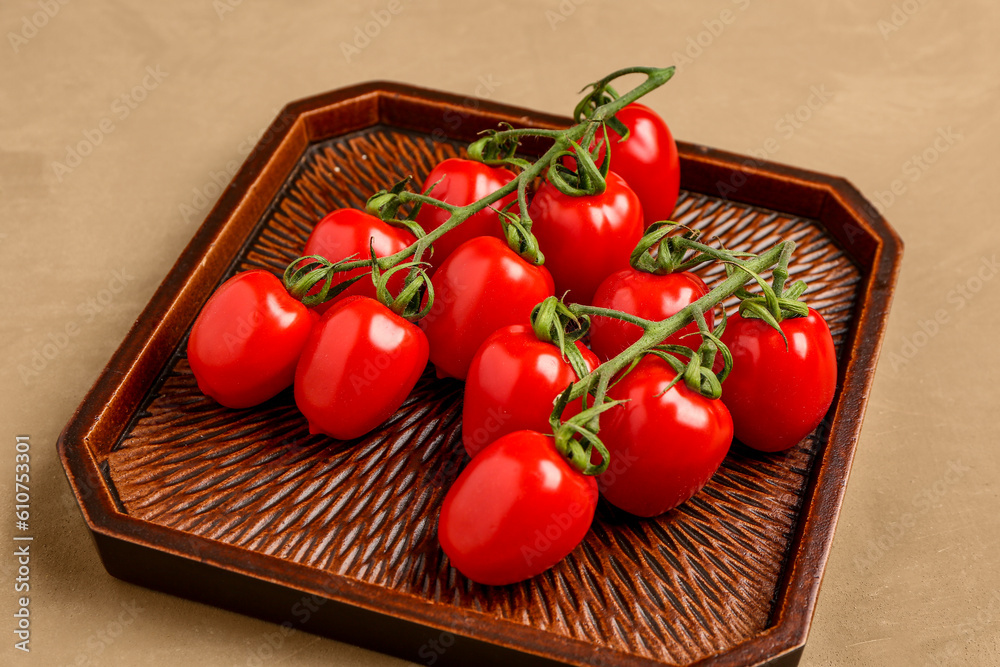 Tray with fresh cherry tomatoes on brown background