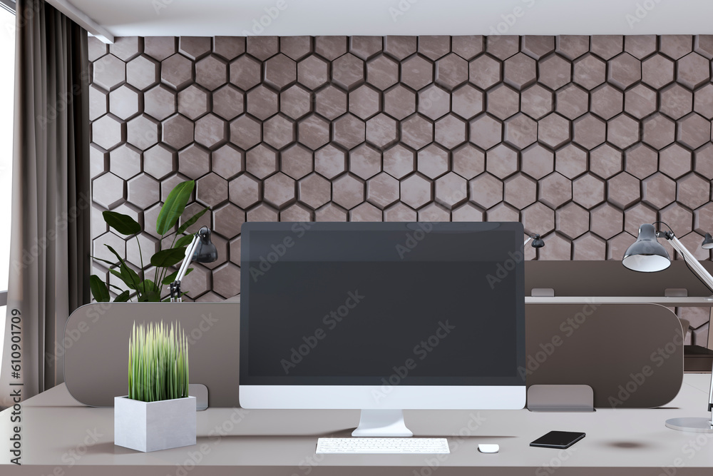 Close up of creative designer office interior with decorative wall, empty computer screen and other 