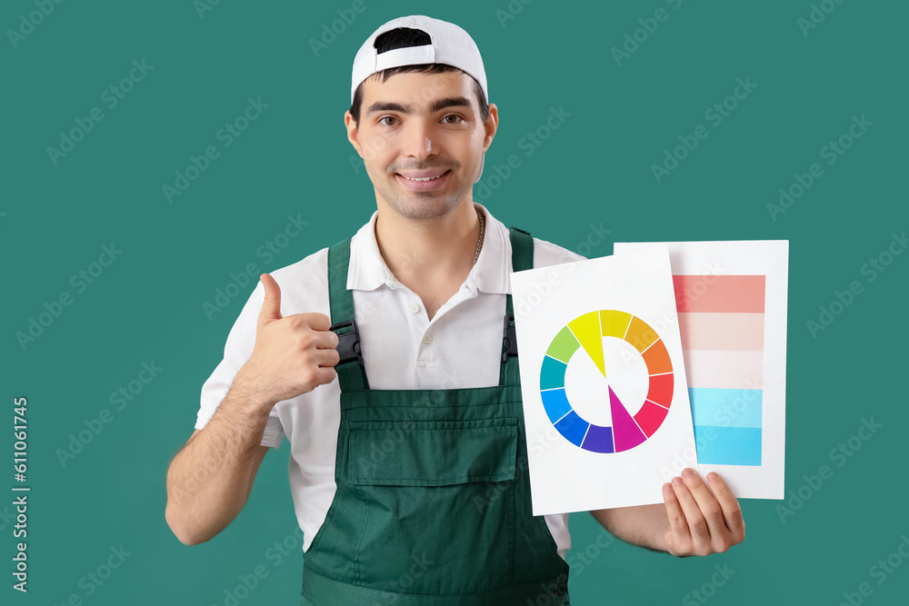 Male painter with color palettes showing thumb-up on green background