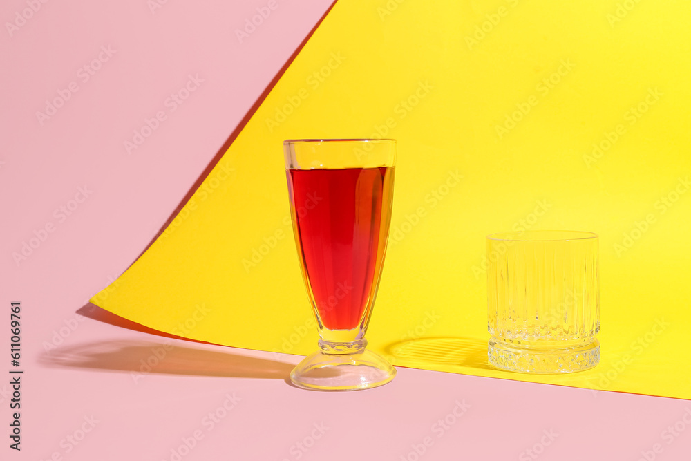 Glasses of fresh pomegranate juice on colorful background